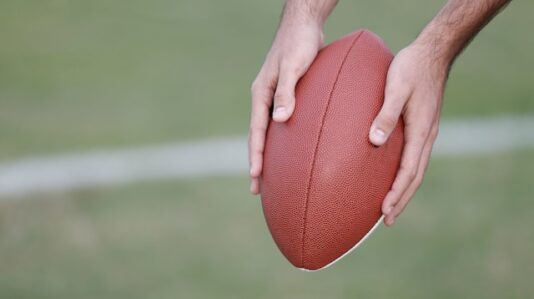 a person holding a football ball