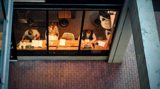 top view shot of three people sitting and reading