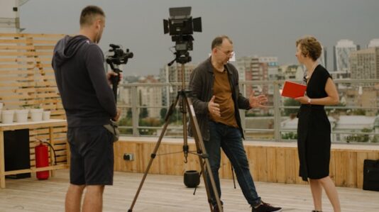 two actors talking with a camera man