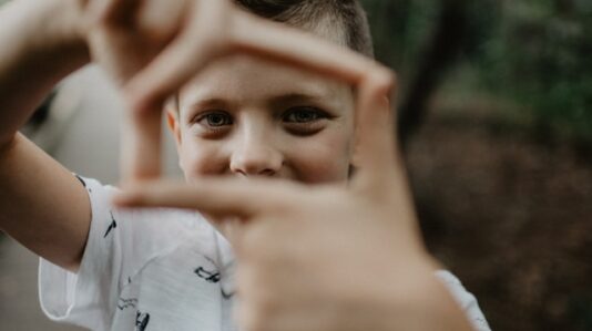 a kid trying to picture something using his hand