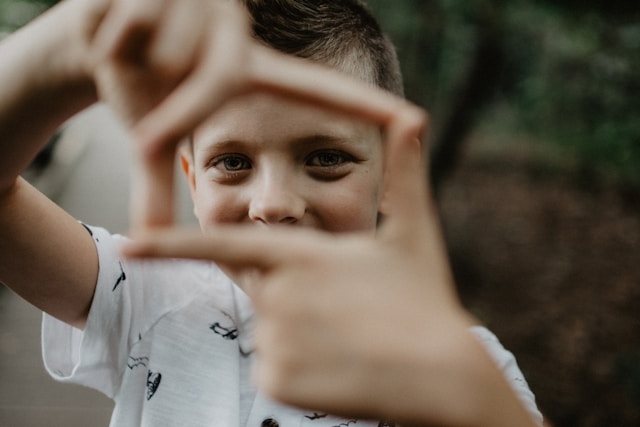 a kid trying to picture something using his hand