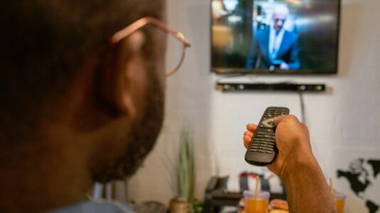 a man holding a tv remote control